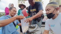 Petani membagikan beras kepada warga di depan Kantor Pemkab Jember. (Foto: Ambang)