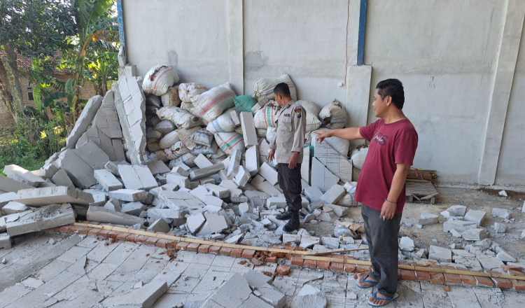 Anggota Polsek Mumbulsari mengecek gudang tembakau yang ambruk di Desa Karang Kedawung. (Foto: Dokumentasi Polsek Mumbulsari)