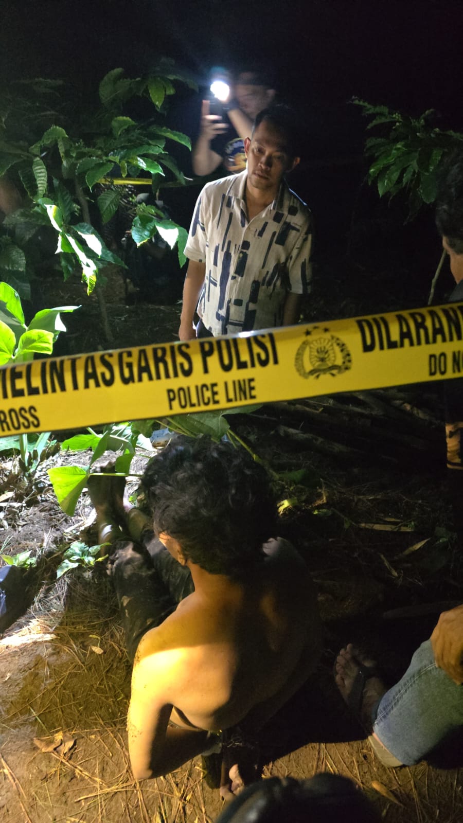 Foto: Kasat Reskrim Polres Jember AKP Angga Riatma, saat bersama pelaku menunjukkan lokasi korban dikubur.