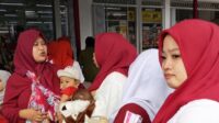 JURNAL BANGSA Ibu-Ibu sedang menggendong balitanya saat menghadiri kegiatan Program Alfamart Sahabat Posyandu (Foto: Istimewa).